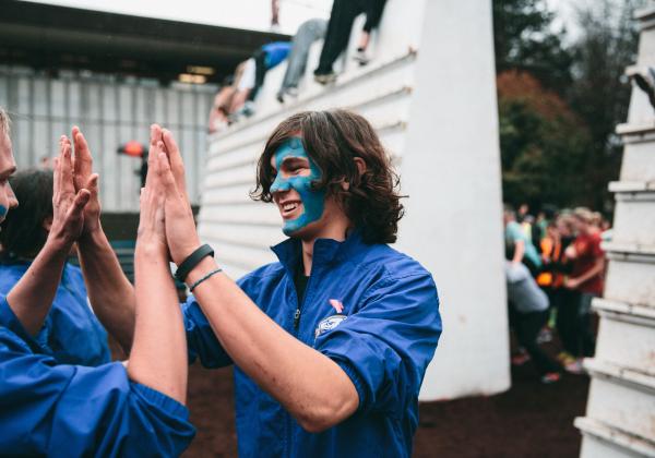 UBC student high-fives his teammates after completing the Storm the Wall tradition